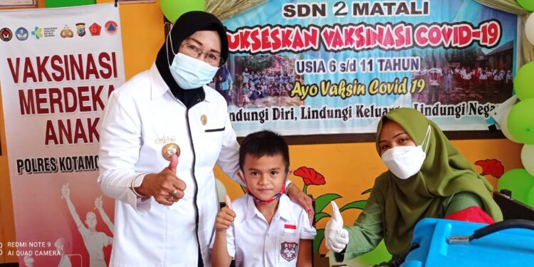 Kepala SDN II Matali, Rohani Potabuga saat mendampingi siswa menjalani vaksin Covid-19 bagi anak usia 6-11 tahun. (Foto:Anggi)