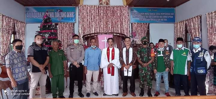 Sangadi Desa Pinonobatuan, Nasrudin mamonto foto bersama Anggota TNI/Polri, GP Ansor Boltim, dan Jemaat GMIBM Baitel Moyongkota. (Foto:Istimewa).